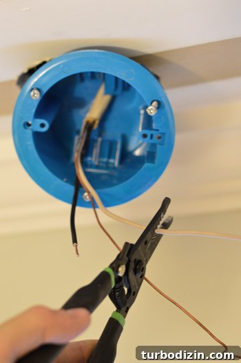 Stripping wires from old fluorescent light fixture while installing new old work box