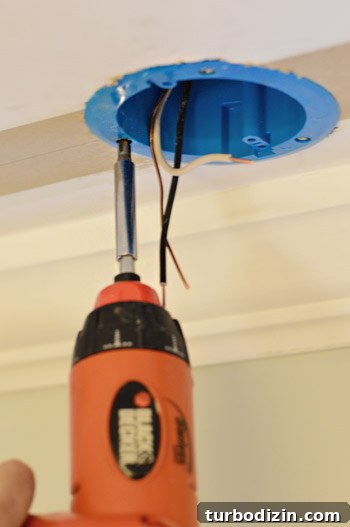 Securing old work electrical fixture box with screwdriver