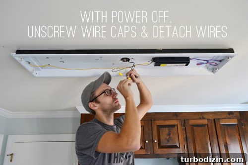 John disconnecting wires in fluorescent light in kitchen