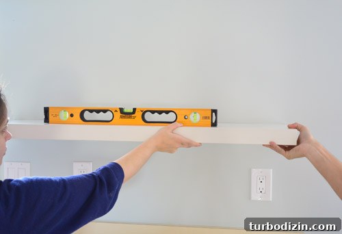 How We Installed Ikea Floating Shelves in Our Kitchen 6 using a level to mark placement of Ikea floating shelves on kitchen wall