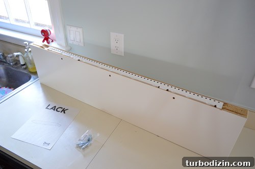 How We Installed Ikea Floating Shelves in Our Kitchen 8 Long LACK floating shelf ready to be hung in kitchen with hanging hardware rail shown