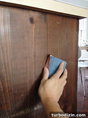 How to Make Wood Cabinets Darker: Step-by-Step Staining Guide 7 Lightly sanding wood cabinets before stain application