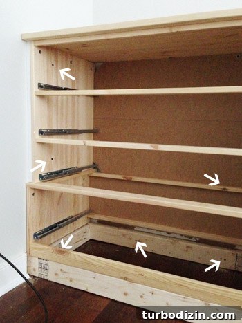 Arrows pointing to screws where Ikea Fjell Dresser was attached to wall and 2x4 base