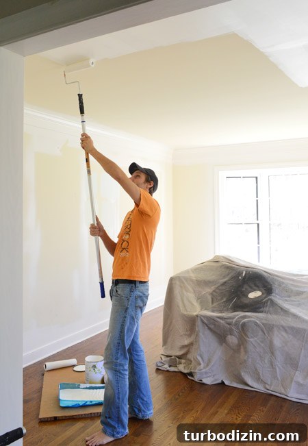 Step-by-Step Guide to Painting a Room Like a Pro 4 John Applying Paint to Ceiling With Roller On Extension Pole