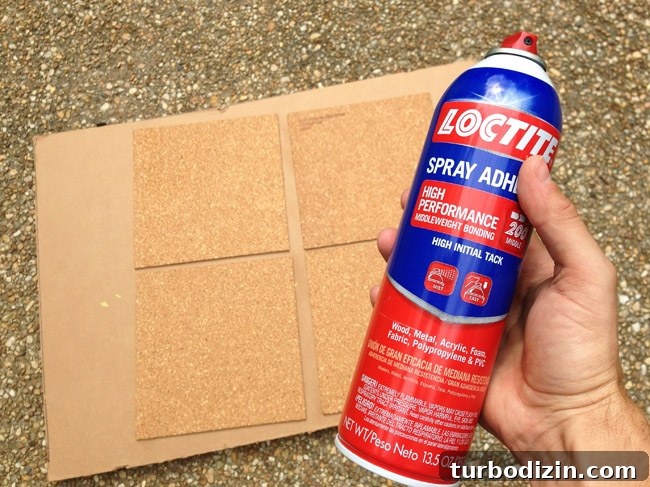 Create a Cork Wall Gallery for Kids’ Artwork 8 spraying loctite spray adhesive on cork board tiles to affix them to cork board wall