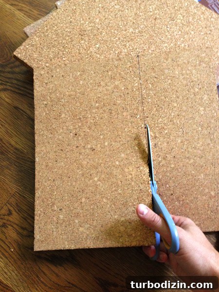 Create a Cork Wall Gallery for Kids’ Artwork 10 using scissors to cut cork tiles to fit to size on cork board wall
