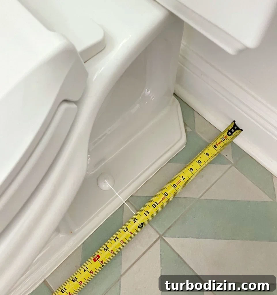 Tape Measure Taking Rough In Measurement By Toilet Bowl