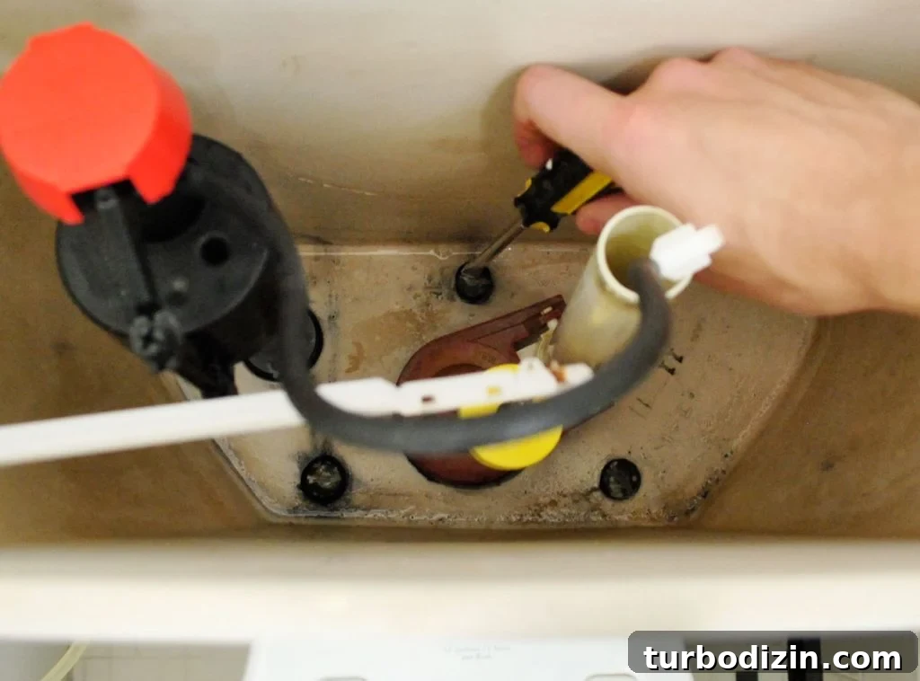 Hand Unscrewing Bolts Inside Toilet Tank
