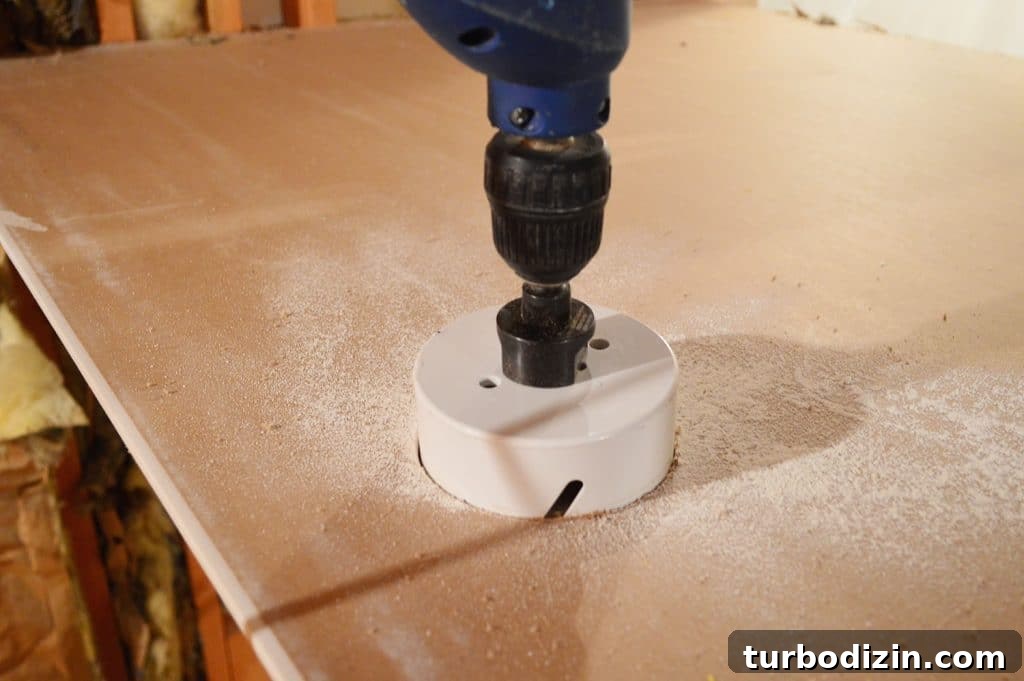 How to Hang Drywall Solo: A Step-by-Step Guide for DIYers 11 drill with hole cutting bit attached sawing through drywall sheet