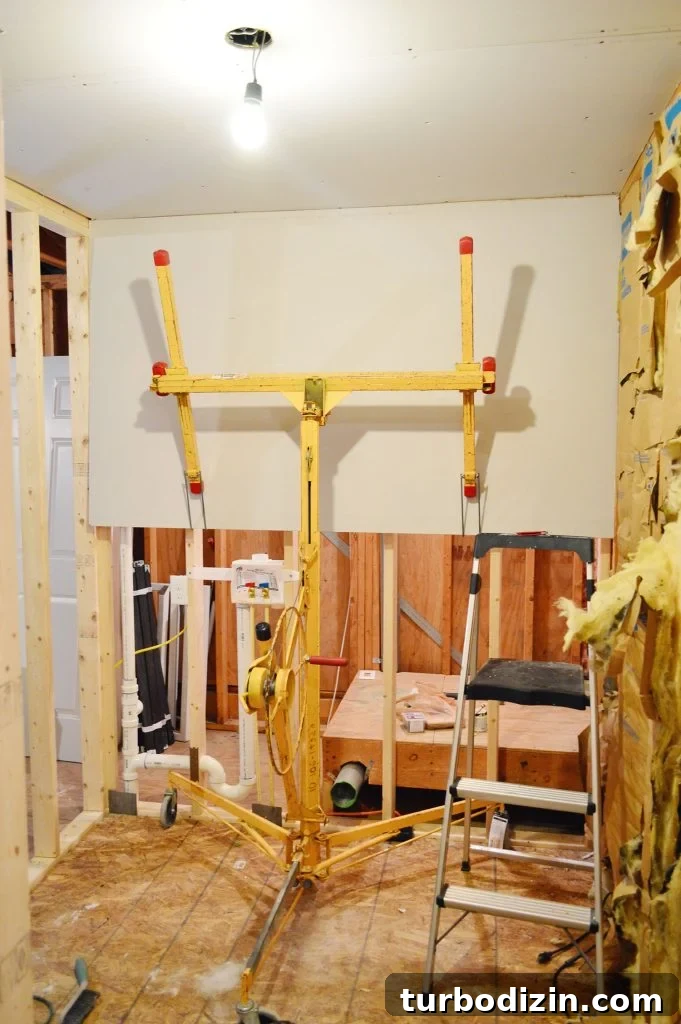 How to Hang Drywall Solo: A Step-by-Step Guide for DIYers 14 drywall lift holding sheetrock panel in place against wall