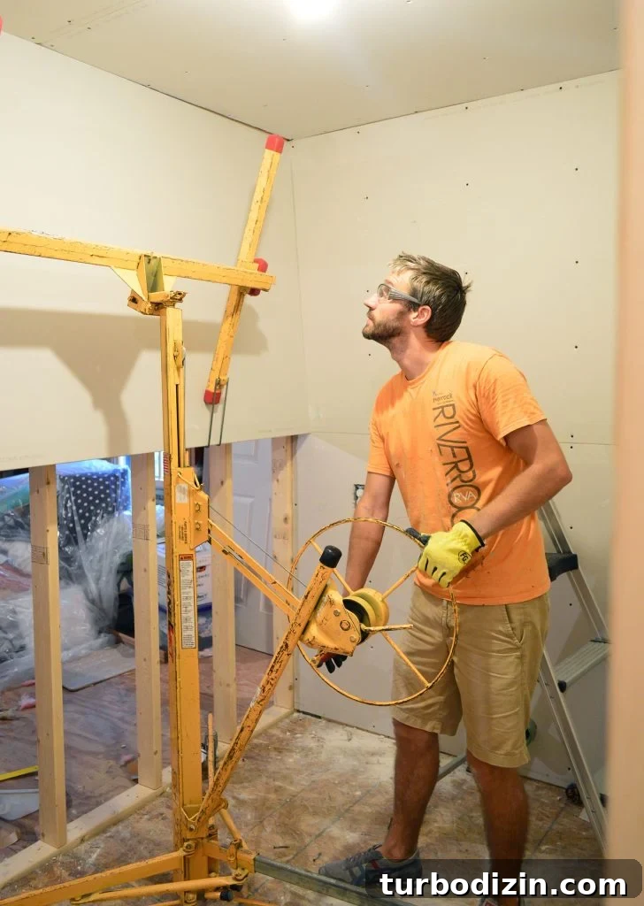 How to Hang Drywall Solo: A Step-by-Step Guide for DIYers 15 John lifting drywall panel into place on laundry room wall