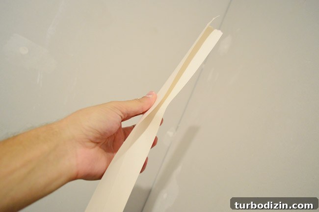 Drywall Taping, Mudding, and Sanding: Step-by-Step Guide 15 hand folding drywall tape along seam before pressing in corner