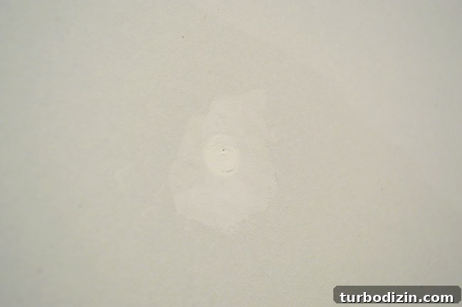 Drywall Taping, Mudding, and Sanding: Step-by-Step Guide 22 screw head with dried joint compound over it that has shrunk slightly