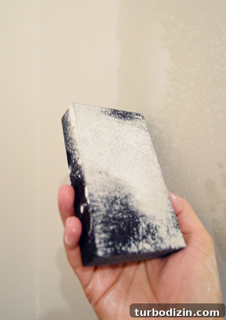 Drywall Taping, Mudding, and Sanding: Step-by-Step Guide 33 wet sanding block with wet dust coating it after drywall sanding