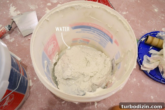 Drywall Taping, Mudding, and Sanding: Step-by-Step Guide 35 bucket of joint compound with a little bit of water in it to thin it out