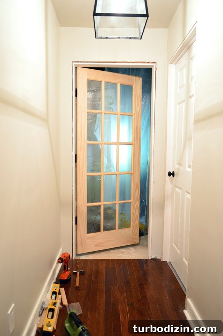How to Hang a Door: Step-by-Step Guide for a Perfect Fit 27 15 Pane Glass Unfinished Wood Door Hung At Entrance To Bonus Room In DIY Door Jamb