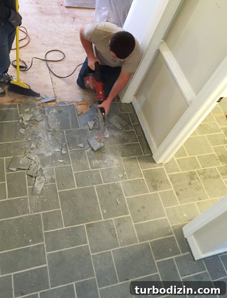 How to Refinish Hardwood Floors: Step-by-Step Guide 5 Man Using Demolition Hammer To Remove Slate Floor