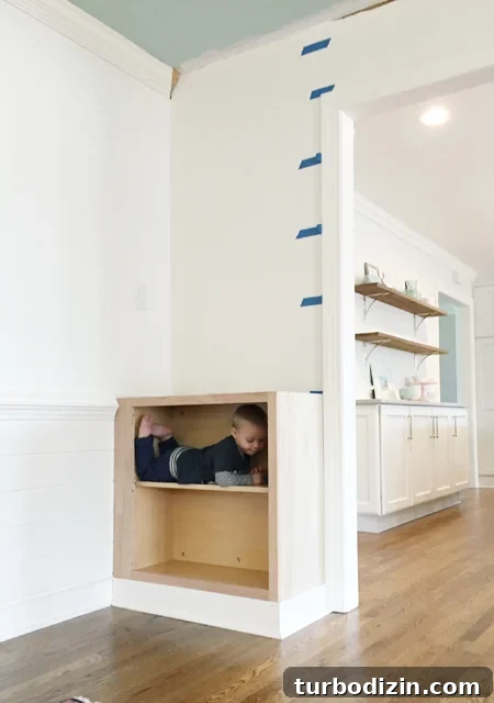 How to Build Custom Built-In Bookshelves for Your Home 11 Base cabinet installed for built-in bookshelf with toddler inside