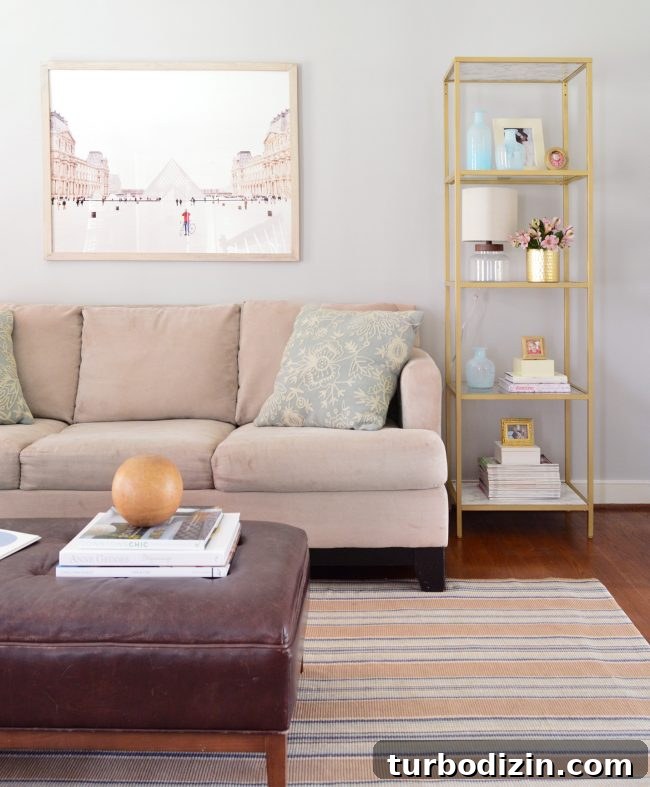 neutral living room with gold shelves and large art