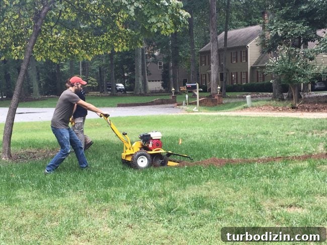 using trencher tool to dig irrigation system in front yard