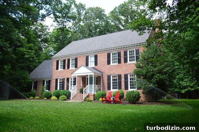 irrigation system watering lawn of brick colonial home