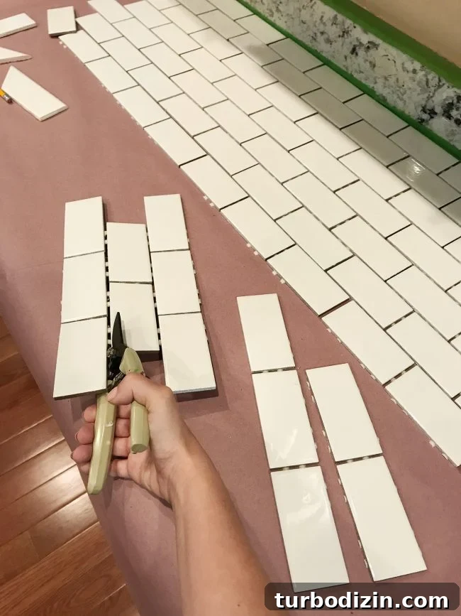 Install a Subway Tile Kitchen Backsplash for $200 DIY Guide 10 Sherry using scissors to cut tiles off subway tile sheet