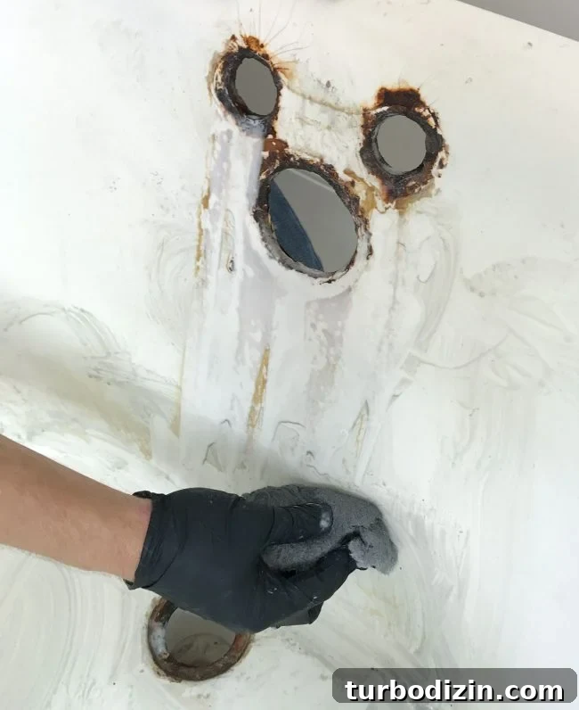 Wiping stains in clawfoot tub with steel wool sponge