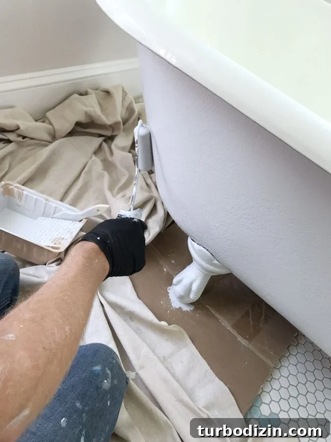 Applying primer to clawfoot tub using a small foam roller