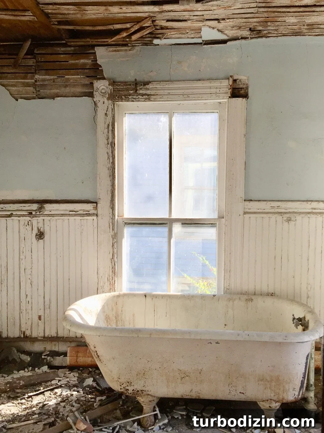 Before photo of beach house bathroom with crumbling walls and dirty tub