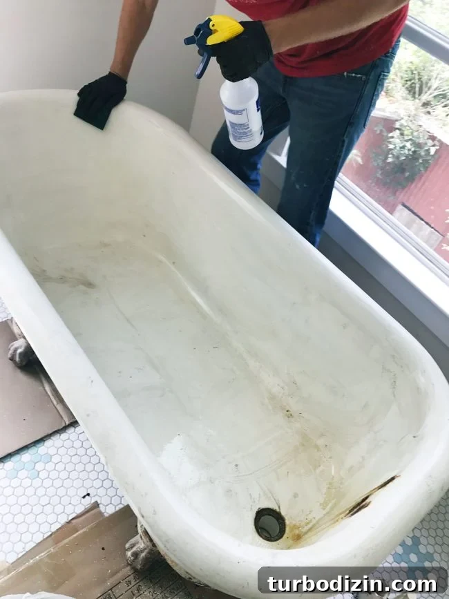 Cleaning clawfoot tub with sponge and vinegar