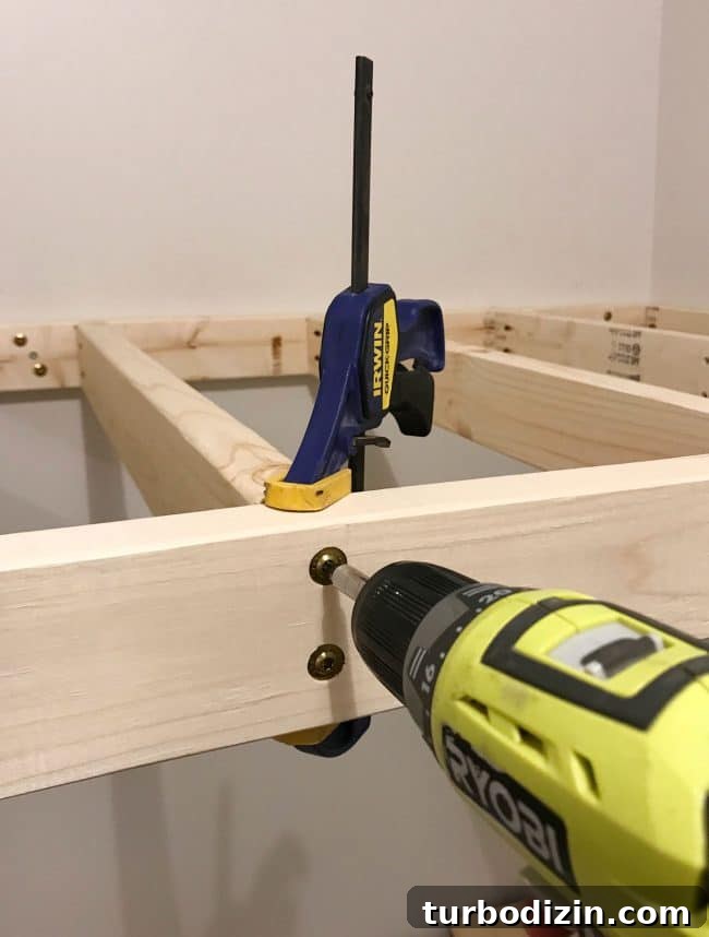DIY Guide: Building Custom Built-In Bunk Beds for Your Home 14 using clamps to drill top bunk supports into place