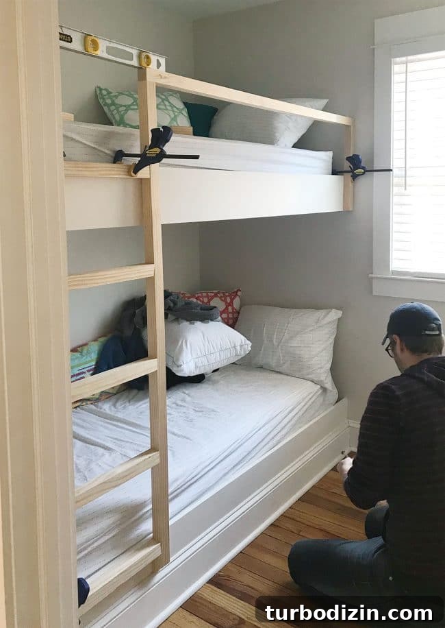DIY Guide: Building Custom Built-In Bunk Beds for Your Home 19 clamps holding diy bunk bed ladder and railings in place