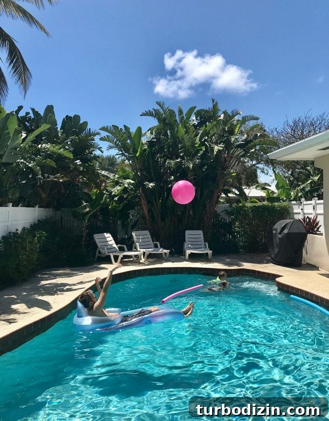 Family Spring Break in Fort Lauderdale: Beaches, Food & Fun Ideas 5 playing in the pool with palm trees around it at beach rental on terra mar island