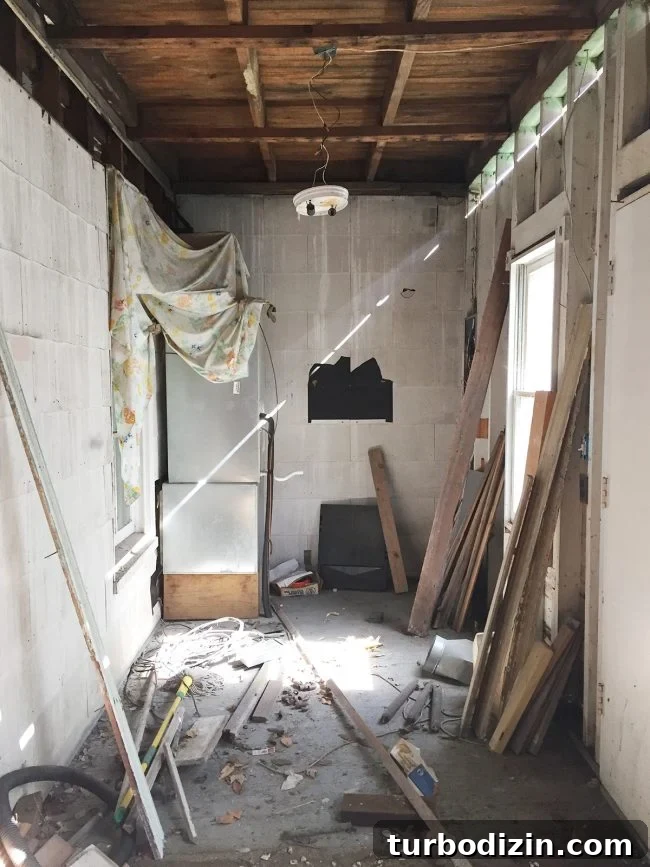 Conceal a Water Heater Using an IKEA Cabinet: Step-by-Step Guide 3 before photo of laundry room with rotting walls and ceilings