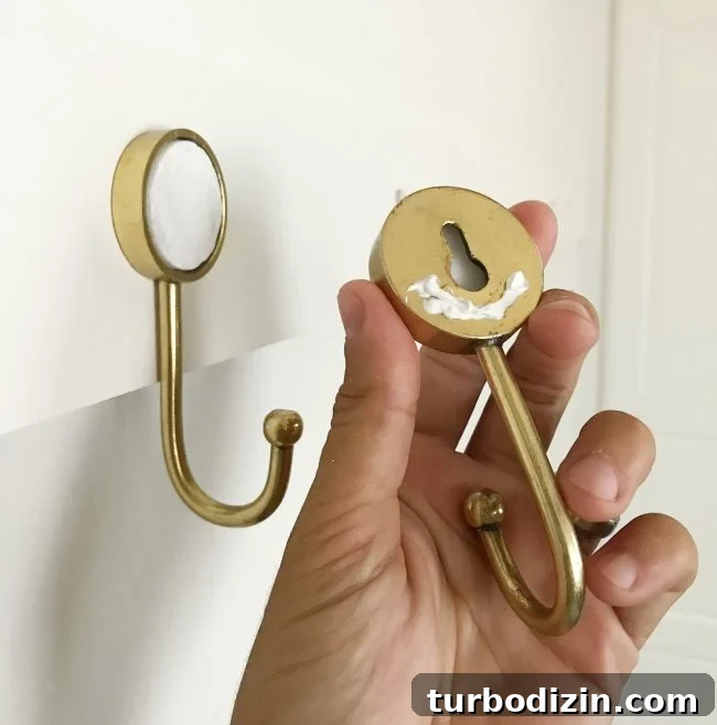 DIY Long Hook Rail for Mudroom: Step-by-Step Build & Install 6 caulk on back of gold hook before being hung on wall