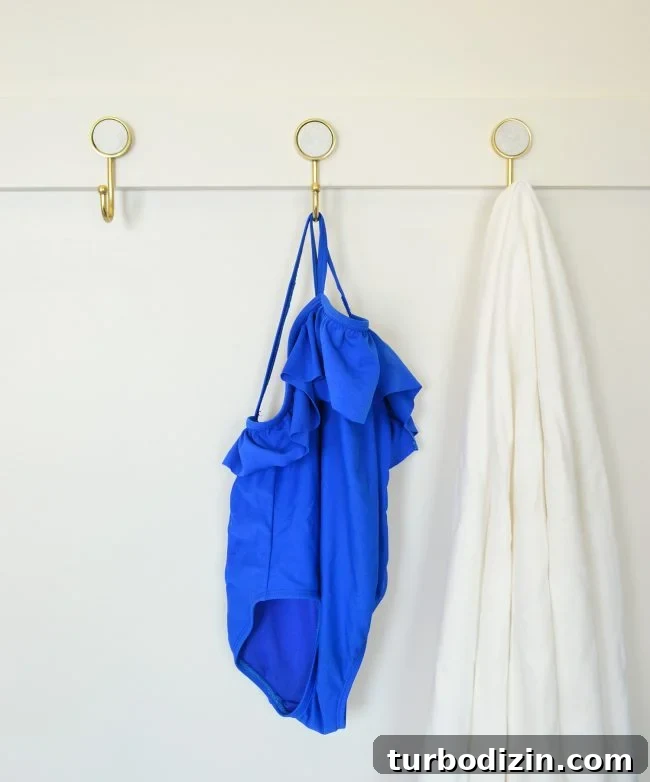 DIY Long Hook Rail for Mudroom: Step-by-Step Build & Install 9 three gold hooks on diy rail with towel and bathing suit