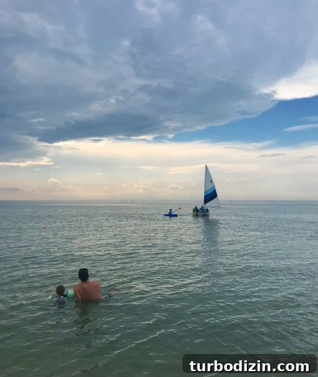 Cape Charles, Virginia: Your Complete Guide to the Beach Town 9 people sitting in water watching sailboat on cape charles beach