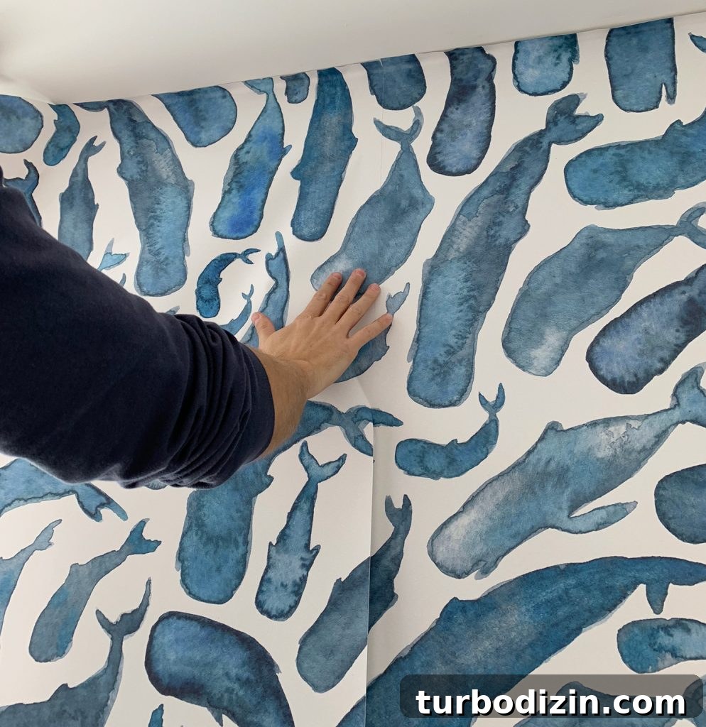Installing Second Panel of Removable Wallpaper Aligning Whale Patterns