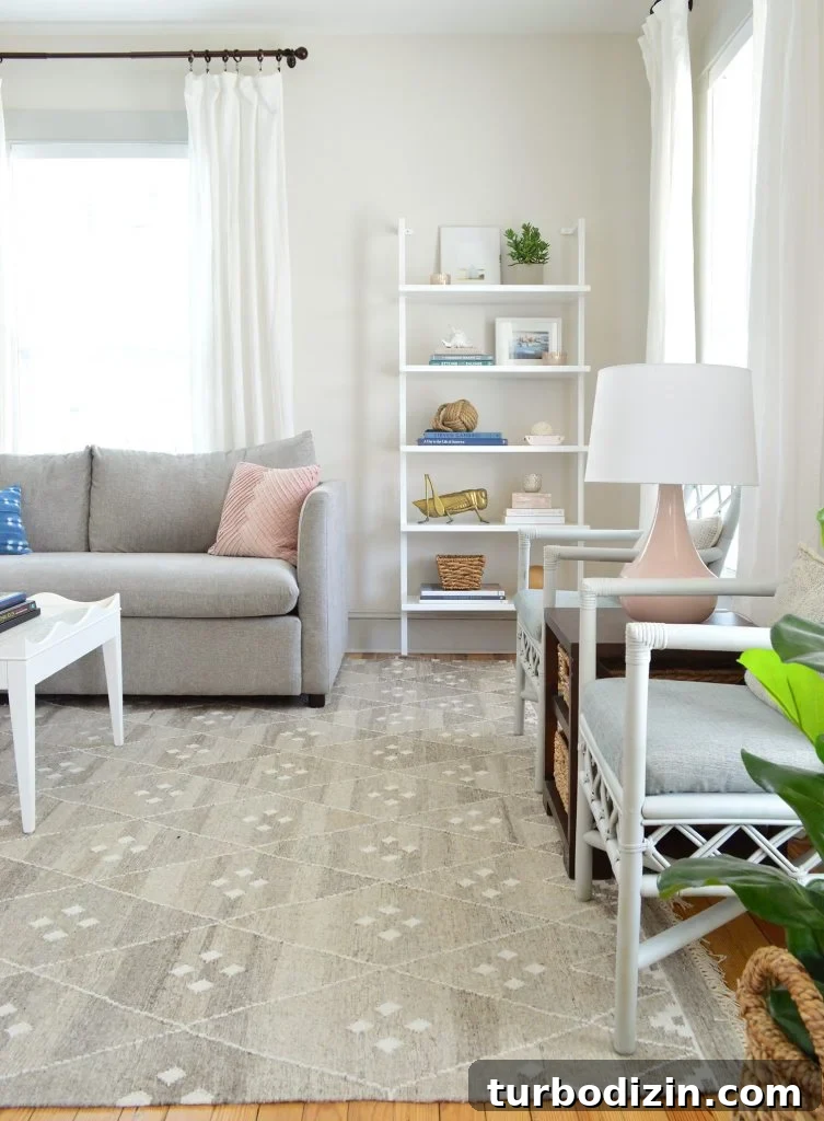 Bright, Airy Living Room Ideas That Stay Comfortable and Practical 14 tall CB2 bookcase in neutral gray living room with pink lamps and accessories