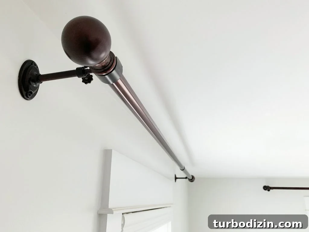Allen + Roth Bronze curtain rods hung against white wall