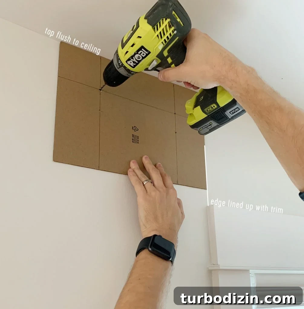 Drilling through curtain rod hanging template to create pilot holes