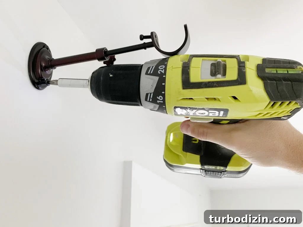 Attaching curtain rod hook using power drill