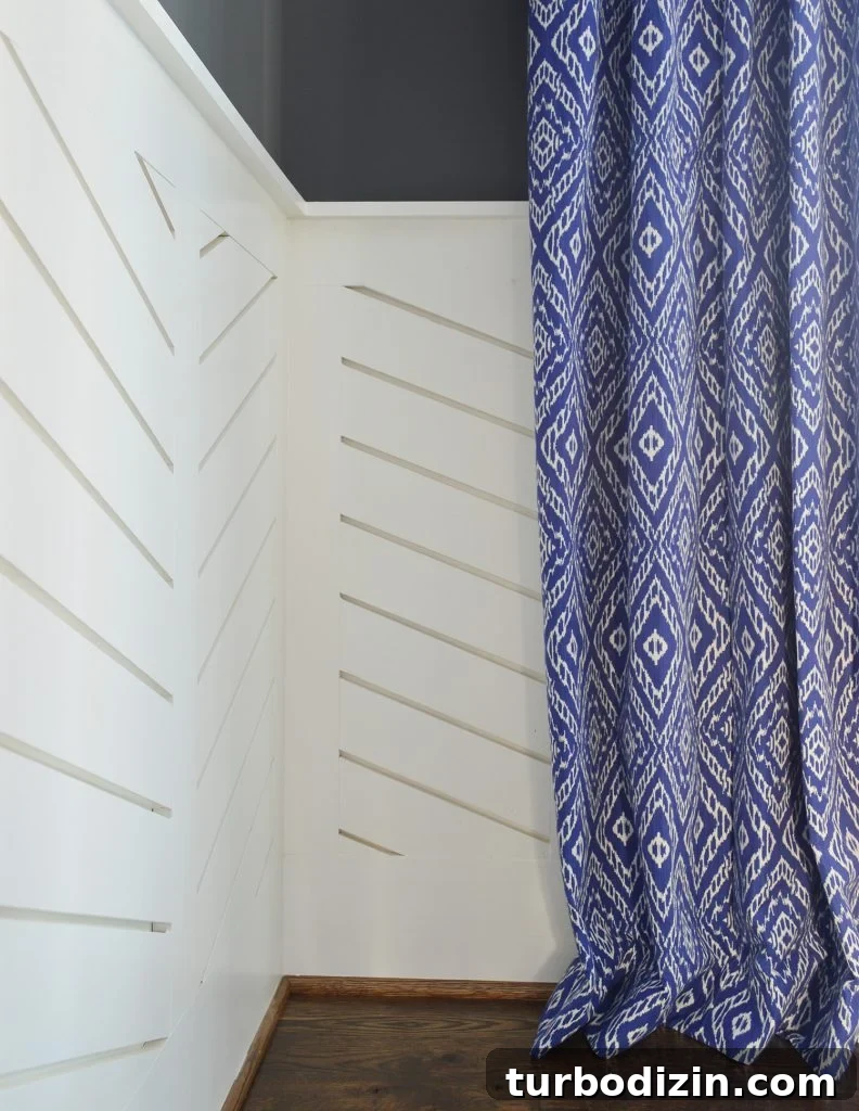 Chevron wainscotting with blue diamond curtain hanging to graze floor