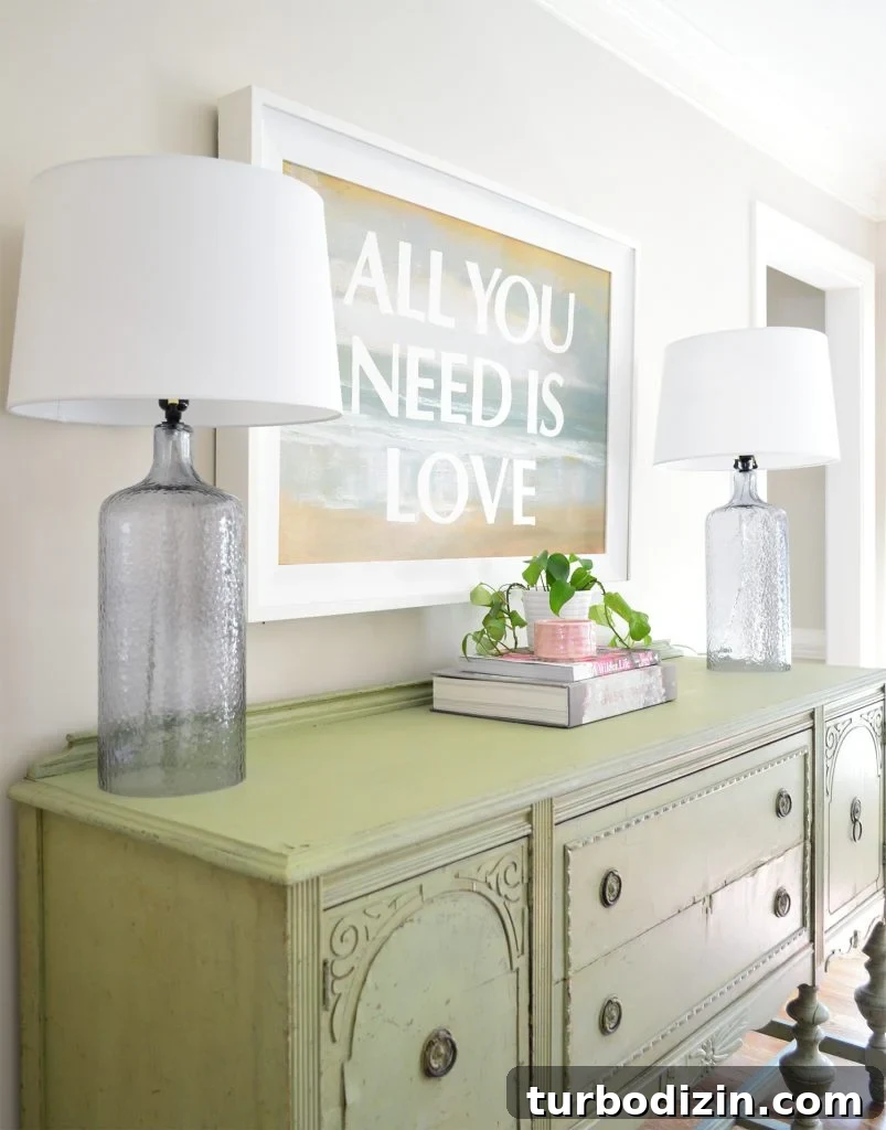 Low-Maintenance Houseplants and Lifelike Faux Alternatives 3 Dining room with vintage green buffet and green ivy plant under All You Need Is Love painting