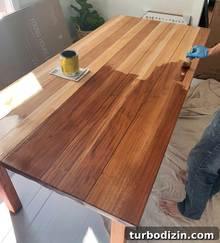 Refinish a Wooden Table: Step-by-Step Guide for Smooth Results 14 Minwax Stain Being Applied To Wood Dining Table During Refinishing
