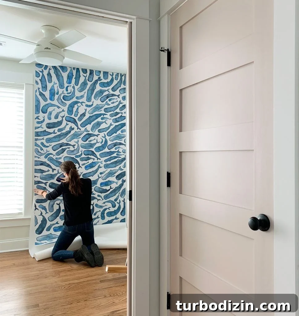 Family-Friendly Airbnb: Kids’ Bedrooms & Storage Tips 4 Sherry Smoothing Second Panel of Removable Wallpaper With Pink Door In Foreground