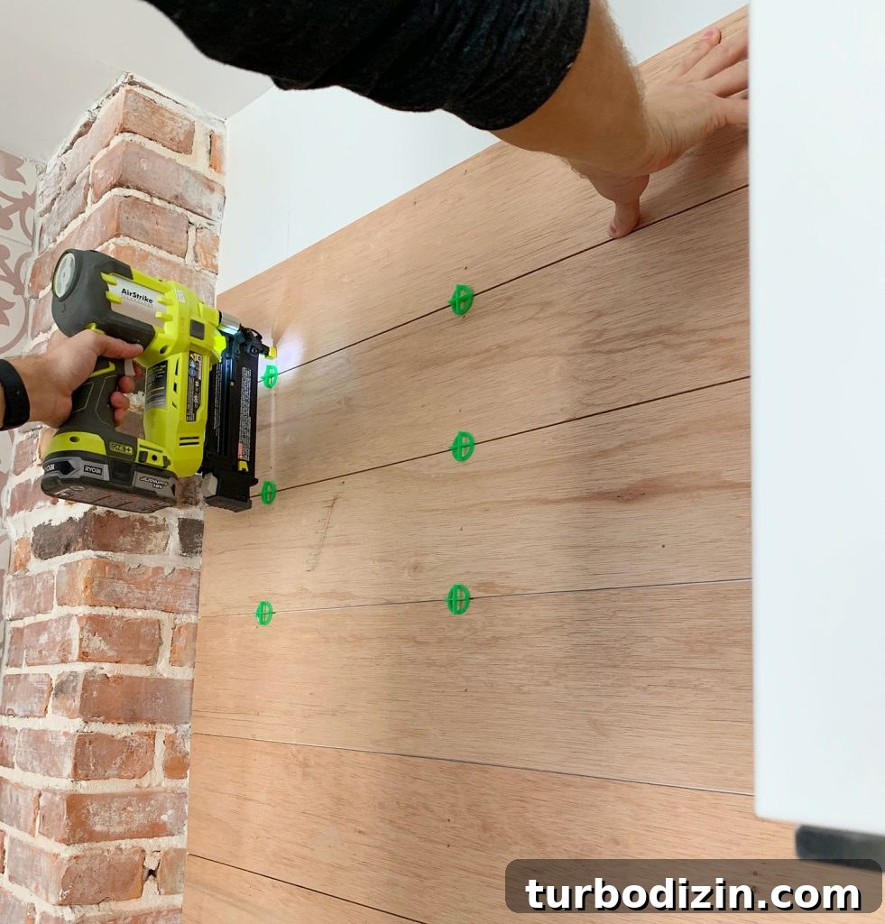 DIY Shiplap Wall Plank Makeover for $31 Total 5 Nail Gun Securing Wood Panels To Backsplash Using Tile Spacers