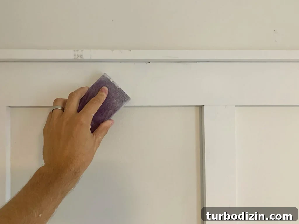Board and Batten Tutorial: Step-by-Step Guide for Stunning Walls 16 Sanding Block Being Used to Smooth Filled Holes On Board And Batten