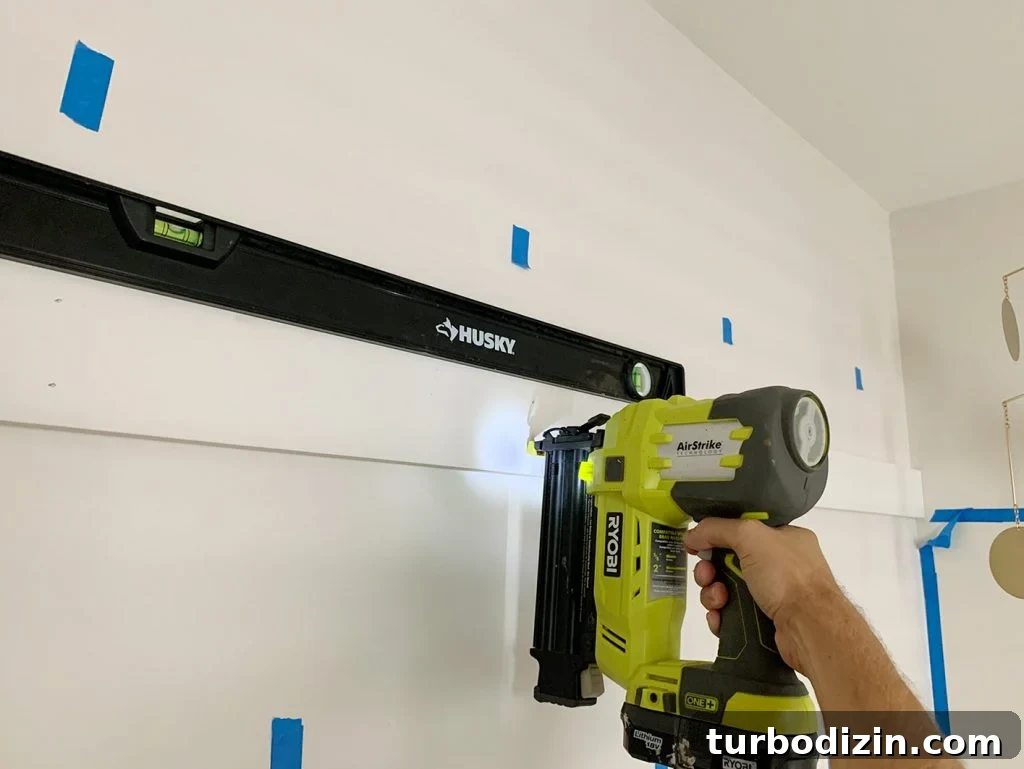 Board and Batten Tutorial: Step-by-Step Guide for Stunning Walls 10 Using Nail Gun To Install Top Rail Of Board And Batten