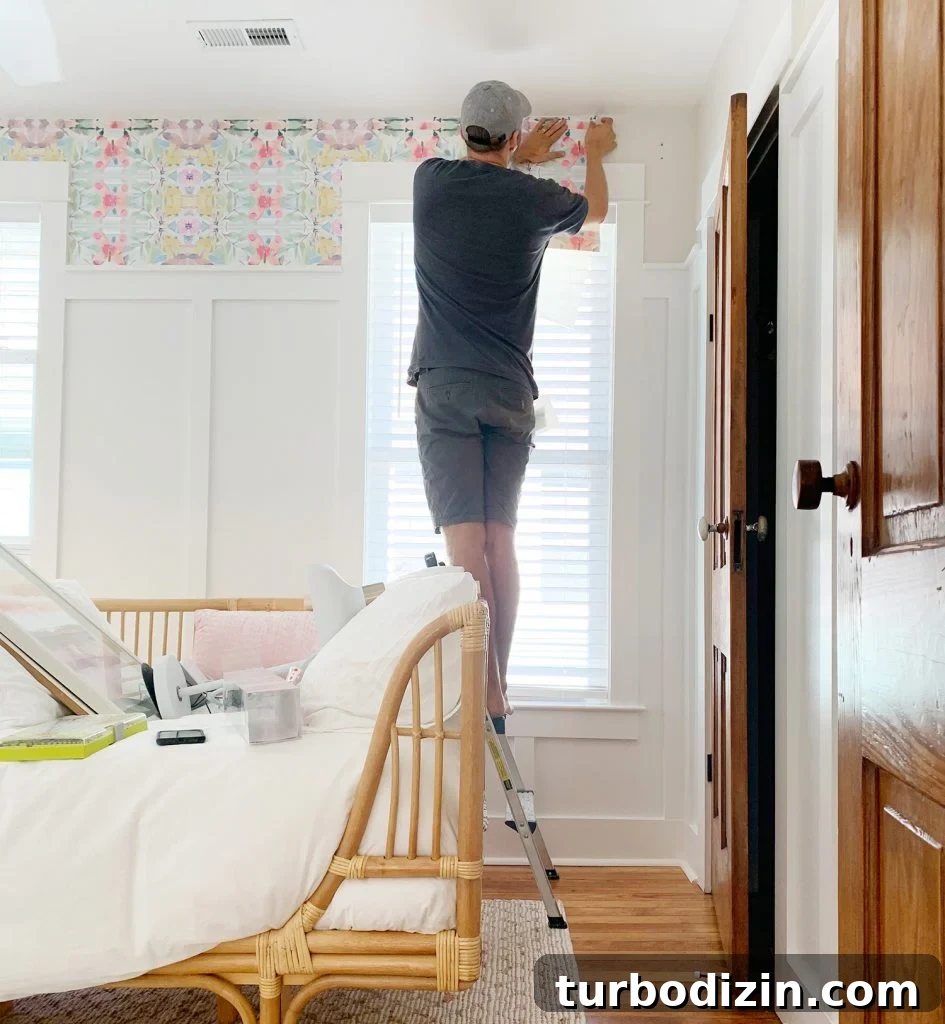 John Sticking Sheet Of Peel And Stick Wallpaper Above Window